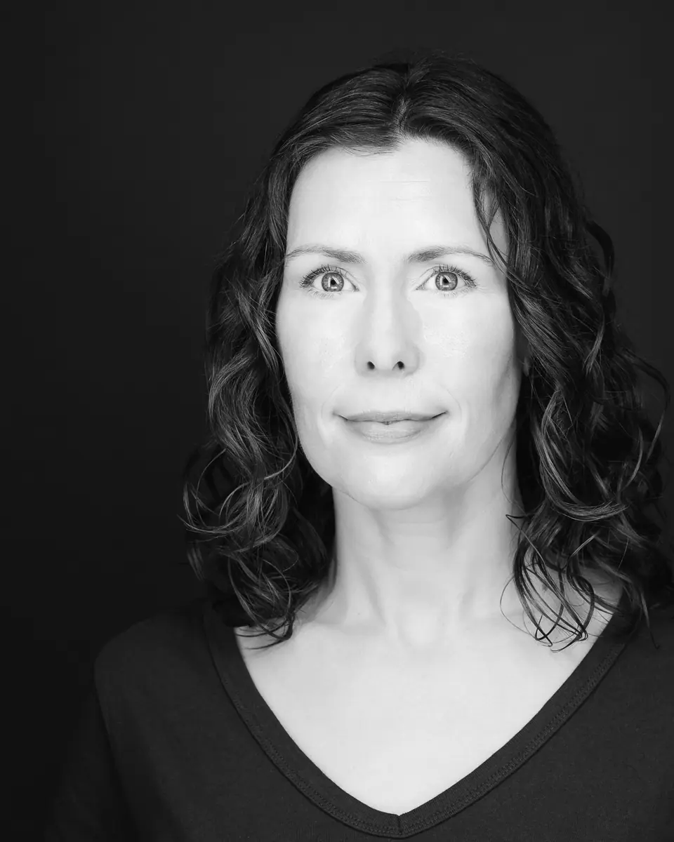 Black and white actor headshot of a woman with curly hair