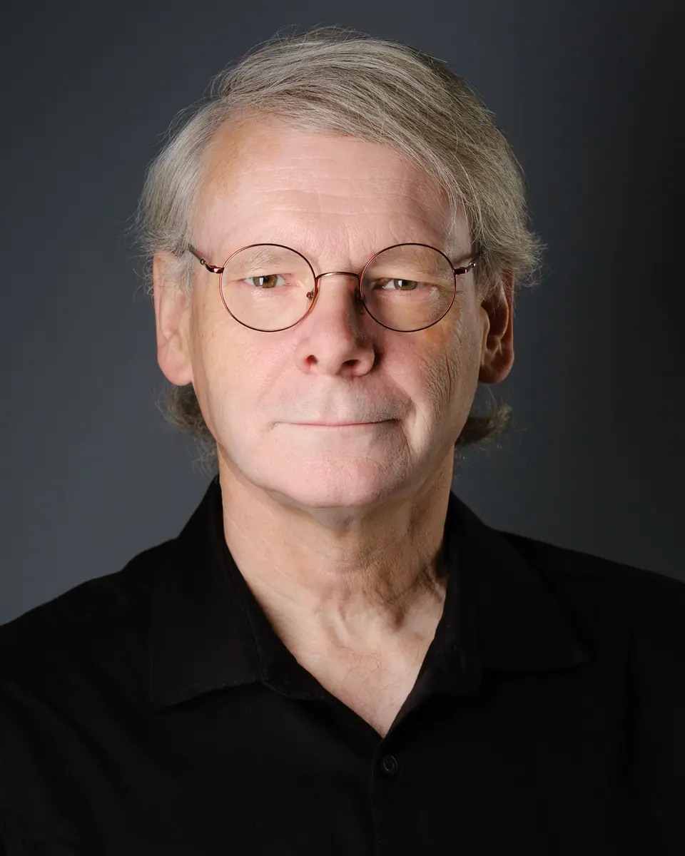 Character actor headshot of an older man with round glasses