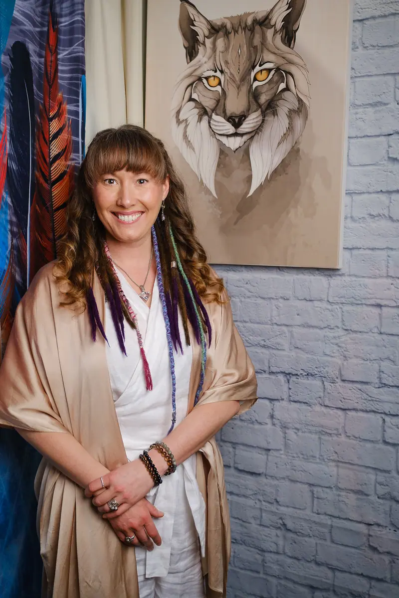 Personal branding portrait of an artist beside her painting of a lynx