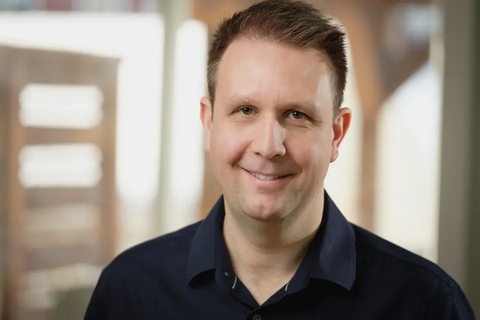 Environmental portrait of a smiling man in a bright office