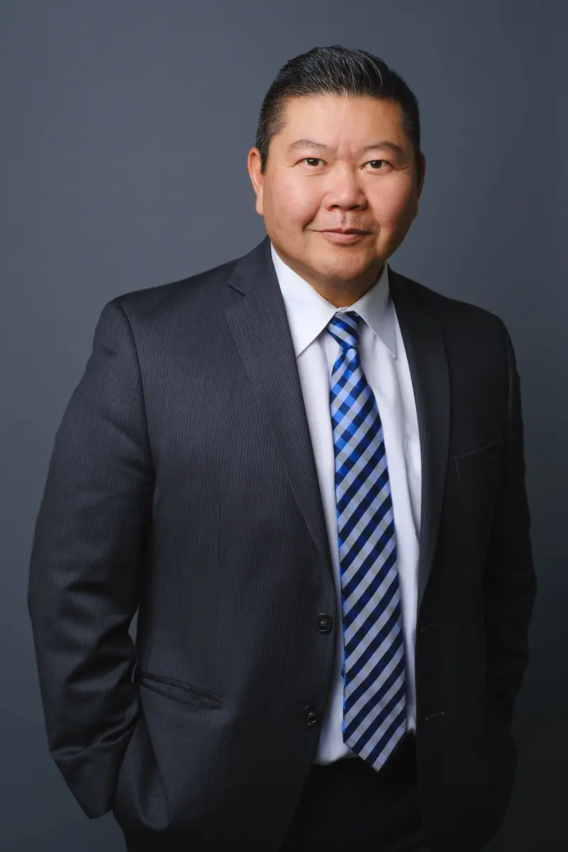 Three quarter corporate portrait of a man in a suit and striped tie