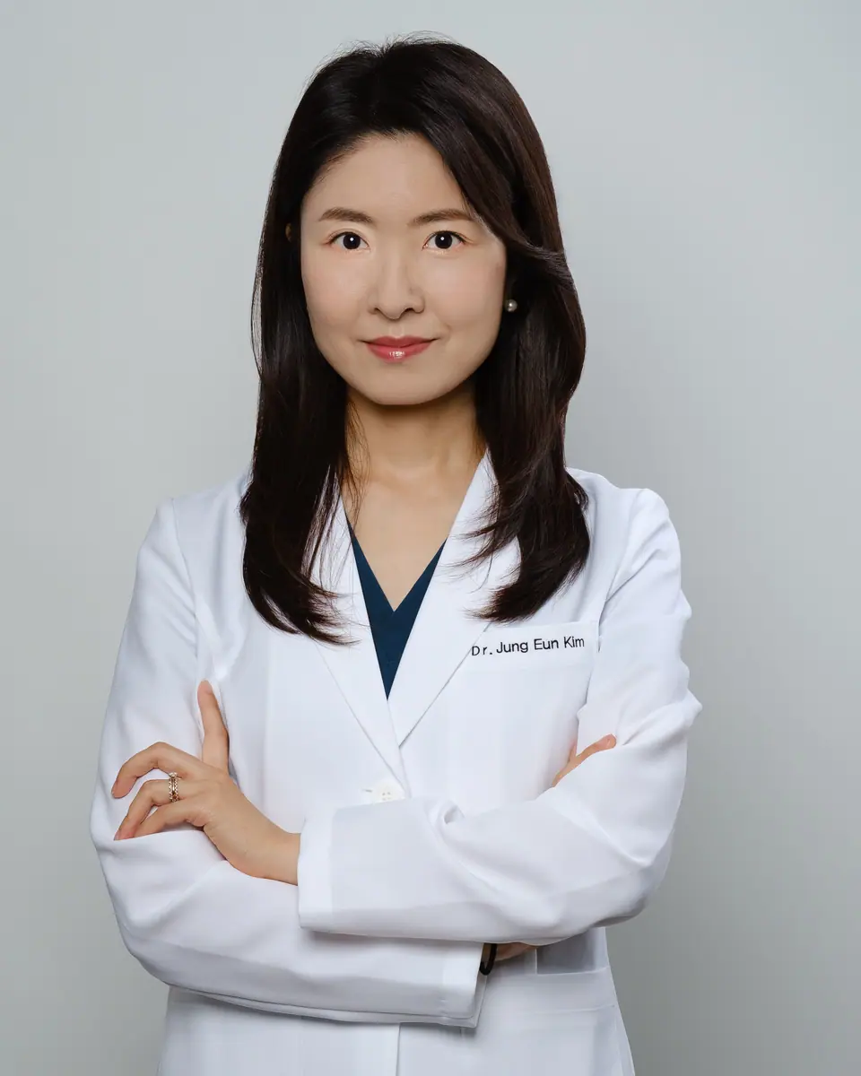 Doctor headshot of a woman in a white coat with her arms crossed