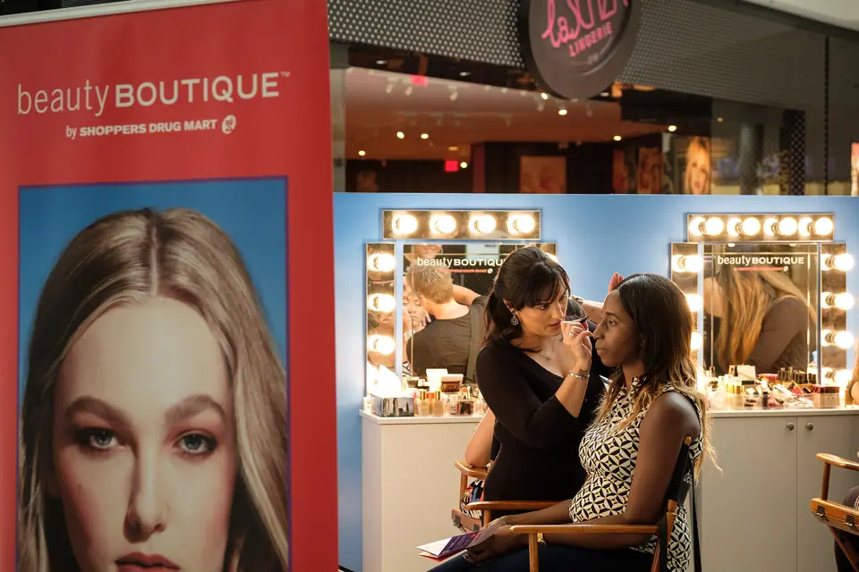 Makeup artists working with guests at a beauty boutique grand opening