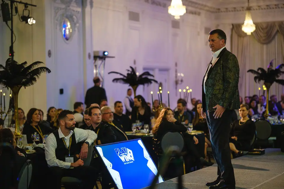 Speaker addressing a full ballroom audience at a conference