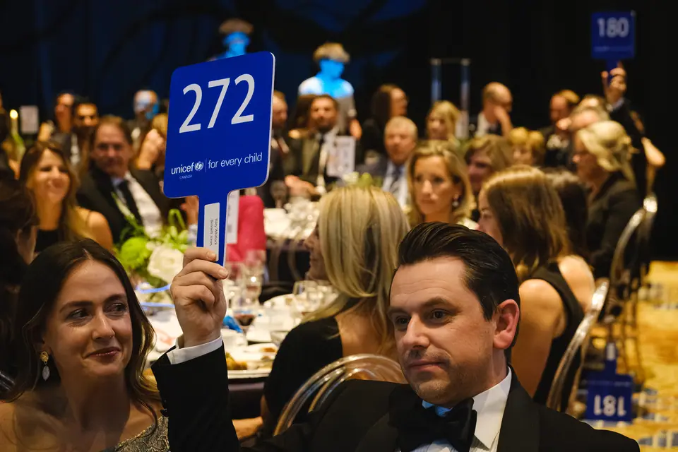 Guests raising paddles during a charity gala auction