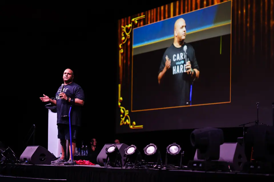 Speaker on stage beside a big screen at the UNICEF Glow for Good gala