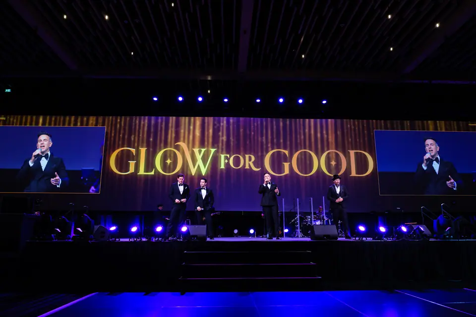 Glow for Good gala stage lit in purple and blue