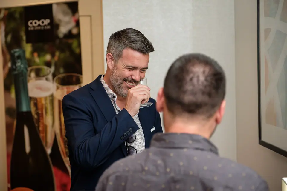 Two guests sharing a laugh while networking at an event