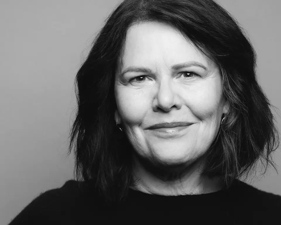 Black and white portrait headshot of a woman with dark wavy hair