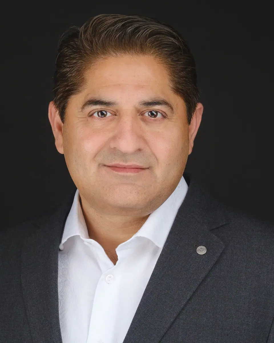 Executive headshot of a man in a charcoal suit and white shirt