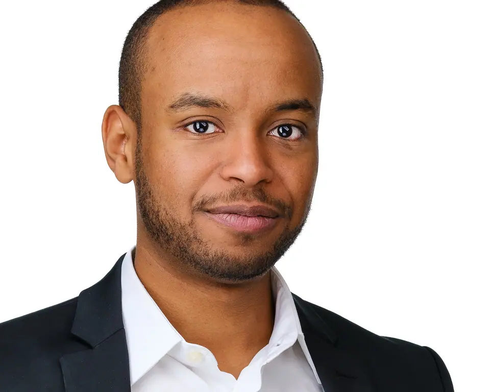 Confident corporate headshot of a man in a black suit and white shirt