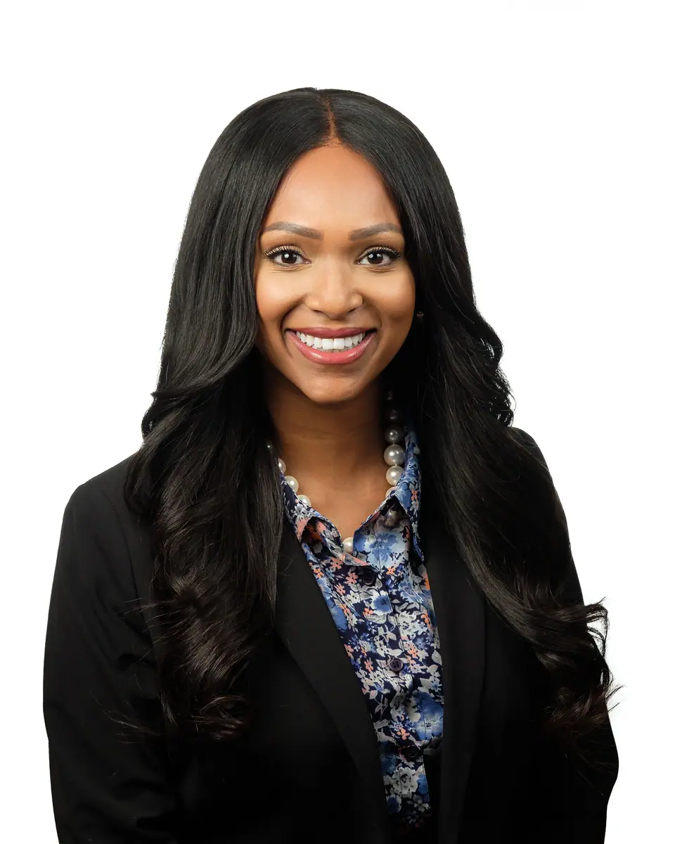 White background headshot of a woman with long dark hair in a black blazer