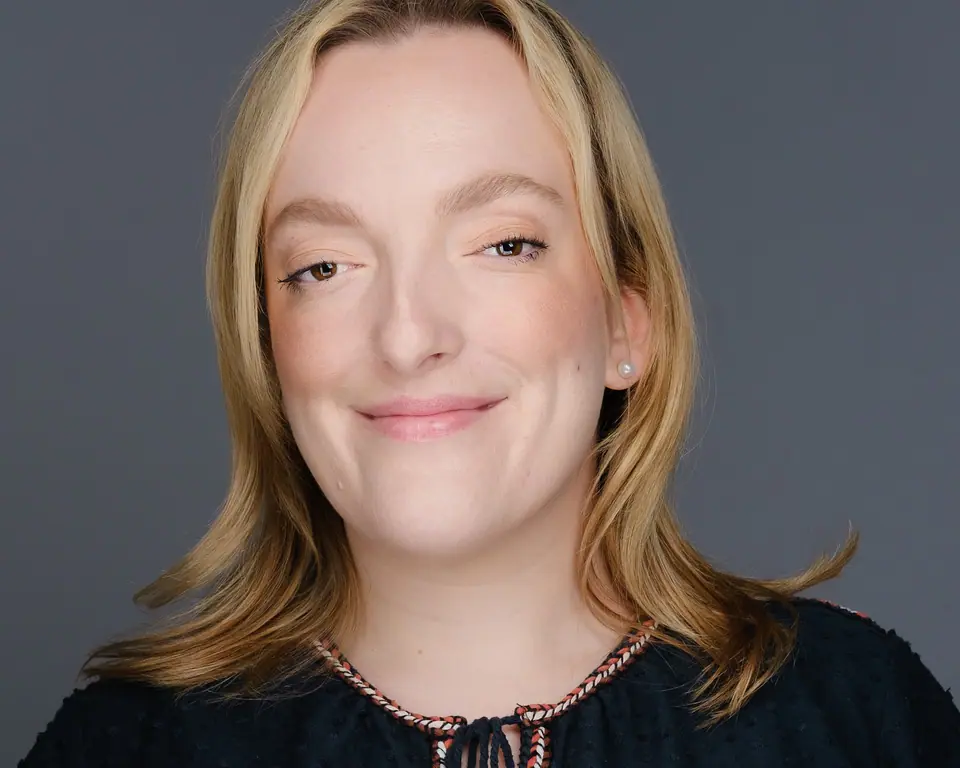 Natural studio headshot of a woman with shoulder length blonde hair