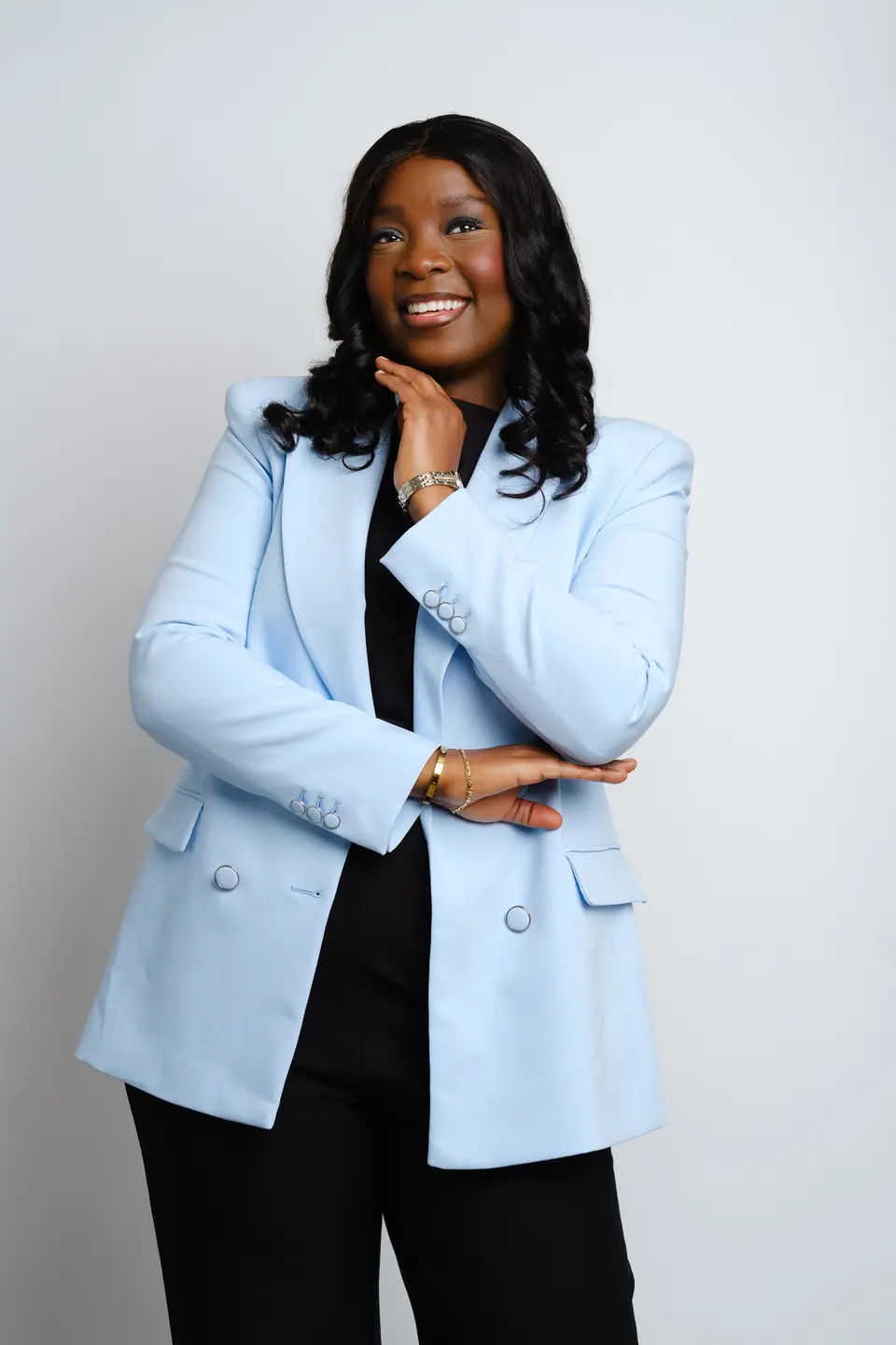 Studio portrait of a smiling woman in a light blue blazer