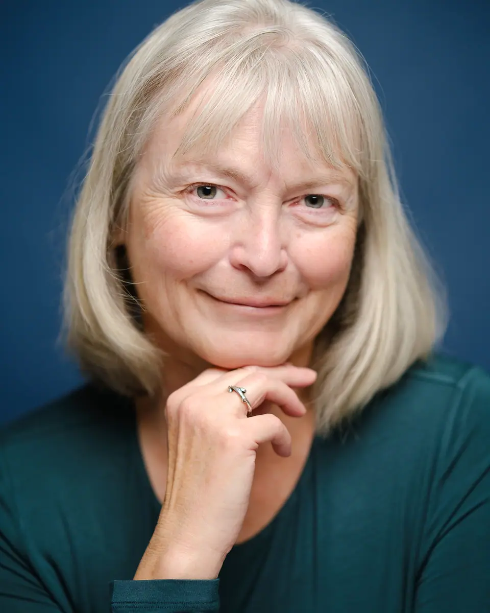 Creative portrait of a woman with silver hair resting her chin on her hand