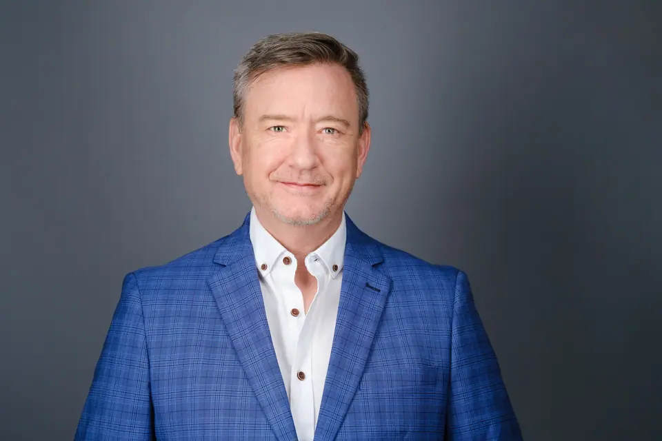 Realtor headshot of a smiling man in a blue check blazer